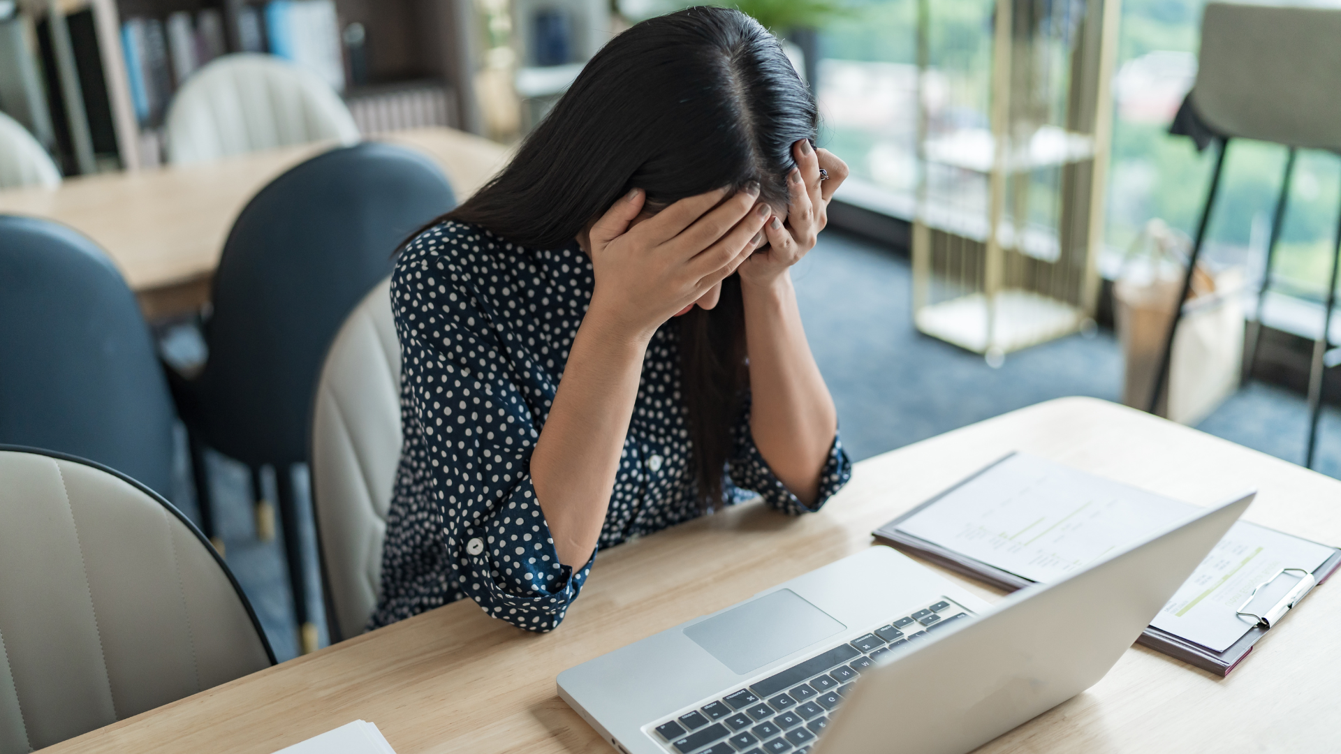 Woman at desk looking stressed after a key employee leaves, highlighting workplace disruption