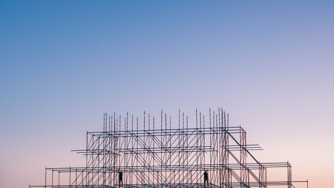 Construction scaffolding framework against twilight sky during building project